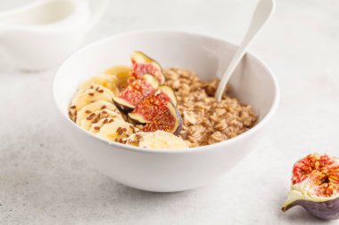 Muz, incir ve keten tohumu Sonbahar yulaf ezmesi. Beyaz arka plan, kavram yeme temiz.