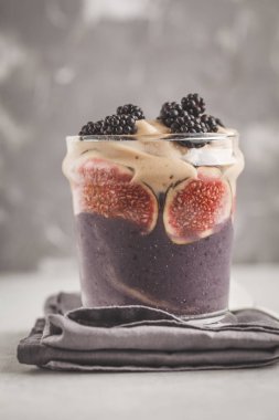 İncir ve böğürtlen güler yüzlü bir cam kavanoza. Temiz yemek kavramı.