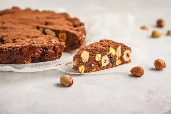 Italian dessert panforte with nuts, chocolate and candied fruits. White background, Italian dessert concept.