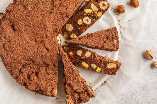 Italian dessert panforte with nuts, chocolate and candied fruits. White background, top view, Italian dessert concept.