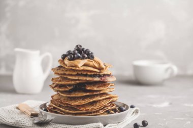 Fıstık ezmesi ve şurubu ile vejetaryen yaban mersinli krep yığını. Temiz yemek kavramı.