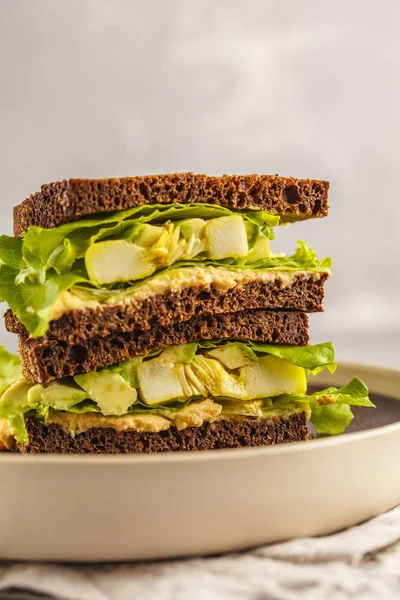 Vegan green sandwich with hummus, baked vegetables and avocado. Clen eting concept.