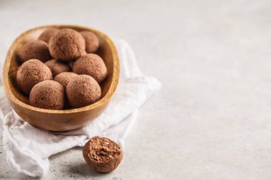 Fındık ve kakao bir ahşap kase, beyaz arka planda çiğ vegan topları. Temiz yemek kavramı.