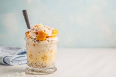 Mango, Hindistan cevizi, muz ve chia tohum gecede yulaf ezmesi. Temiz yemek kavramı.