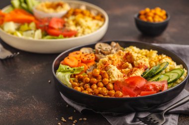 Buda sebze, mantar, bulgur, humus ve pişmiş nohut ile kase. Koyu arka plan. Sağlıklı vegan gıda kavramı.