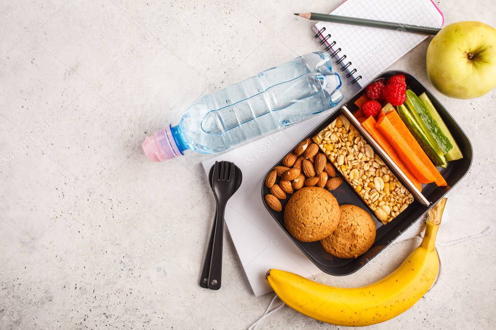 Healthy meal prep containers with cereal bar, fruits, vegetables and snacks. Takeaway food on white background, copy space, top view.