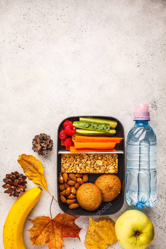 Healthy meal prep containers with cereal bar, fruits, vegetables and snacks. Takeaway food on white background, copy space, top view.