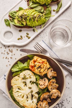 Karnabahar biftek ızgara petrol ve humus ve avokado tost, üstten görünüm. Bitki esaslı diyet kavramı.