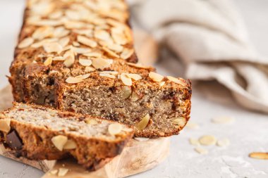 Ev yapımı vegan muz ekmeği ile badem ve çikolata, gri arka plan. Temiz yemek kavramı.