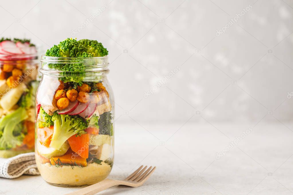 Healthy Homemade Mason Jar Salad with baked vegetables, hummus, tofu and chickpeas. Healthy food, detox, Clean Eating or vegan concept.