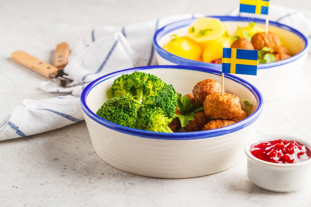 Swedish traditional meatballs with broccoli, boiled potatoes and cranberry sauce. Swedish food concept.