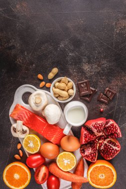 Anti gıda kavramı. Balık, yumurta, narenciye, çikolata, mantar ve fındık alerjisi. Sağlık ve Tıp gıda. Koyu arka plan, üstten görünüm, kopya alanı.