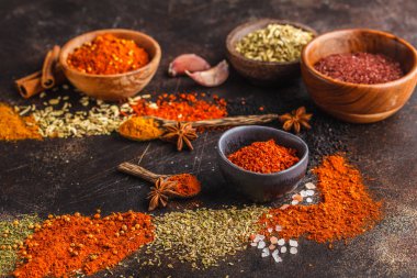 Koyu arka plan üzerinde ahşap kase içinde baharatlar farklı tür. Gıda arka plan.