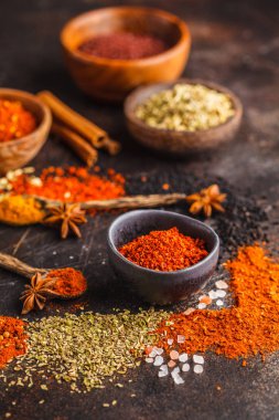 Koyu arka plan üzerinde ahşap kase içinde baharatlar farklı tür. Gıda arka plan.