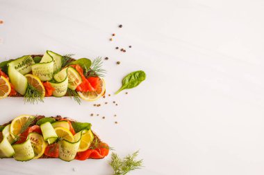 Alabalık (somon) balık sandviç ogerets, çavdar ekmeği ve dereotu ile beyaz bir arka plan üzerine dilimlenmiş.