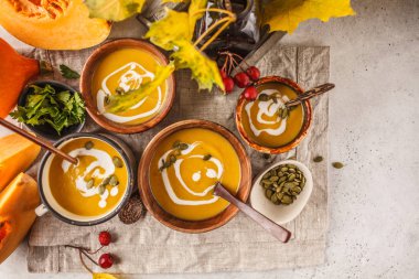 Sonbahar kabak çorbası püresi ile krem bardak, sonbahar sahne. Sağlıklı vegan gıda kavramı. Sonbahar gıda kavramı.