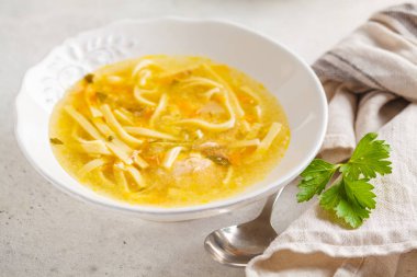 Ev yapımı tavuk çorbası beyaz bir plaka, açık renkli.