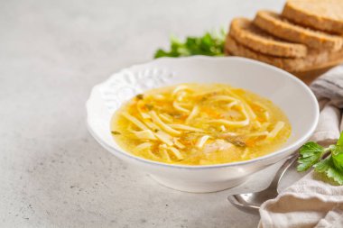 Ev yapımı tavuk çorbası beyaz bir plaka, açık renkli.