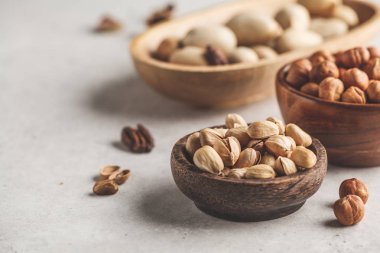 Fındık, fıstık ve pecans beyaz arka plan, kopya alanı üzerinde ahşap kase.