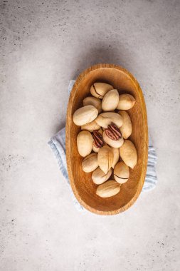 Beyaz bir arka plan üzerinde ahşap bir kase içinde pekan fındık. Bitki esaslı diyet kavramı.