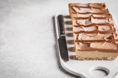 Çiğ vegan çikolata kaju kek hafif bir arka plan üzerine. Bitki esaslı diyet gıda kavramı.