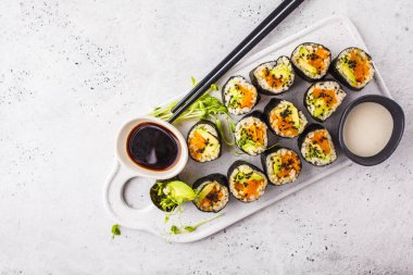 Vegan suşi kabak, kahverengi pirinç ve avokado, kopya alanı ile alır. Bitki esaslı diyet gıda.