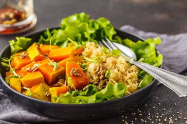 Sıcak quinoa ve beyaz bir tabak içinde kabak salatası. Sağlıklı vegan gıda kavramı, diyet gıda.
