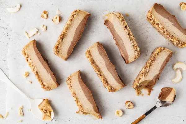 Slices of raw vegan cashew cake on white background, top view. Vegan food, food flat lay.