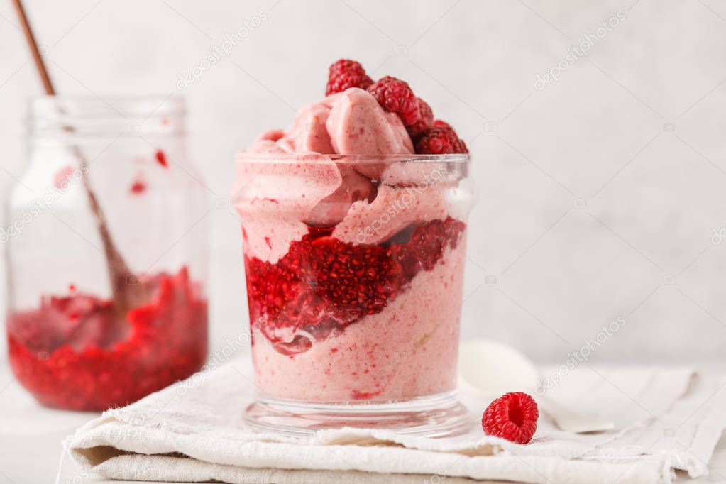 Vegan breakfast raspberry smoothie (ice cream) with berry jam in a jar. Plant based diet concept.