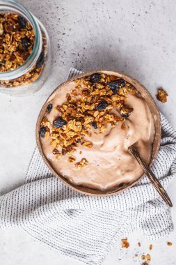 Üstten görünüm bir Hindistan cevizi kasede granola ile çikolata güler yüzlü kase. Sağlıklı vegan gıda kavramı.