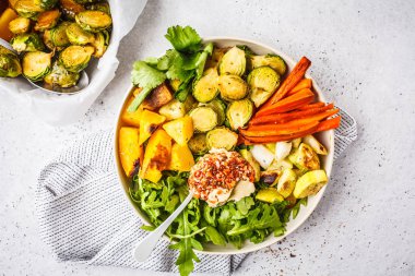 Pişmiş sebze ve humus salata beyaz bulaşık, üstten görünüm içinde. Sağlıklı vegan gıda kavramı.