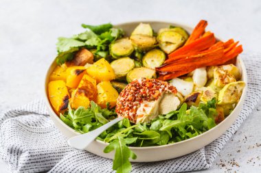 Pişmiş sebze ve beyaz bir tabak içinde humus salata. Sağlıklı vegan gıda kavramı.