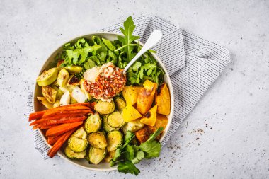 Pişmiş sebze ve humus salata beyaz bulaşık, üstten görünüm içinde. Sağlıklı vegan gıda kavramı.