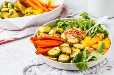 Pişmiş sebze ve beyaz bir tabak içinde humus salata. Sağlıklı vegan gıda kavramı.