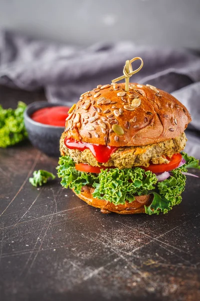Vegan lentil burgers with kale and tomato sauce on a dark background. Plant based diet cincept.