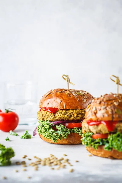 Vegan lentil burgers with kale and tomato sauce on a white background. Plant based food concept.