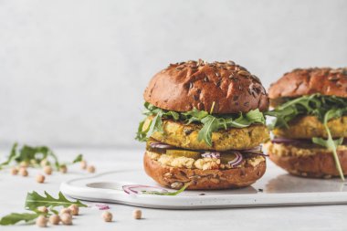 Roka, salatalık turşusu ve humus ile Vegan nohut hamburger. Bitki esaslı diyet kavramı.