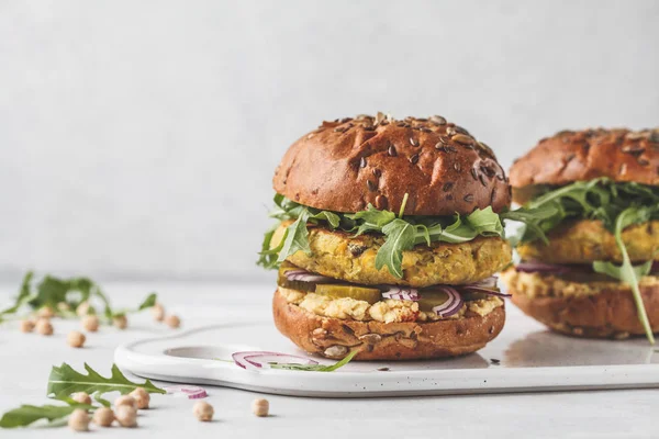 Roka, salatalık turşusu ve humus ile Vegan nohut hamburger. Bitki esaslı diyet kavramı.