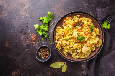 Bir koyu arka plan, üstten görünüm, kopya alanı üzerinde siyah bir tabak tavuk pilav.