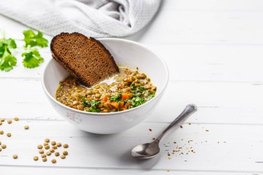 Ev yapımı vegan mercimek çorbası sebze ve Salantro, beyaz tahta arka plan ile. Hint vejetaryen mutfağı.