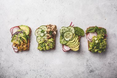 Avokado tost farklı soslar, üstten görünüm, beyaz arka plan ile. Bitki esaslı diyet kavramı.