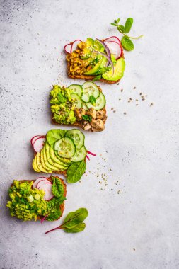 Avokado tost farklı soslar, üstten görünüm, beyaz arka plan ile. Bitki esaslı diyet kavramı.