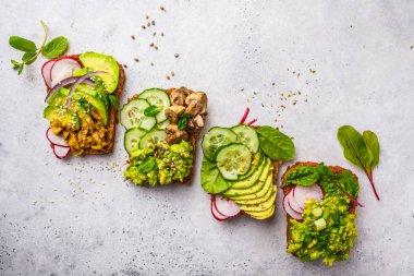 Avokado tost farklı soslar, üstten görünüm, beyaz arka plan ile. Bitki esaslı diyet kavramı.