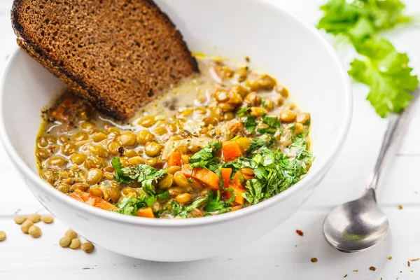 Ev yapımı vegan mercimek çorbası sebze ve Salantro, beyaz tahta arka plan ile. Hint vejetaryen mutfağı.