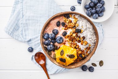 Vegan güler yüzlü kaseyle chia puding, çilek ve granola Hindistan cevizi kabuğu beyaz arka planda, üstten görünüm alanı kopyalayın. Bitki esaslı diyet kavramı.