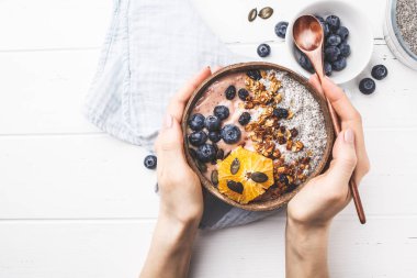 Vegan güler yüzlü kaseyle chia puding, çilek ve granola Hindistan cevizi kabuğu beyaz arka planda, üstten görünüm alanı kopyalayın. Bitki esaslı diyet kavramı.