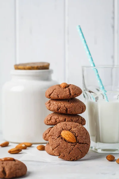 Almond chocolate cookies with milk on a white background. Vegan dessert concept.