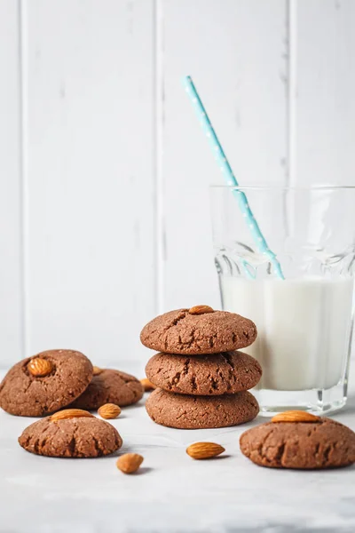 Almond chocolate cookies with milk on a white background. Vegan dessert concept.