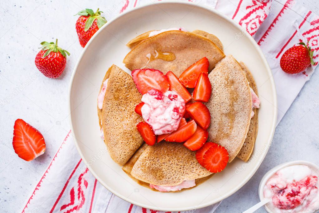 Pancakes with strawberries and yogurt, white background, top view. Breakfast concept.