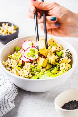 Vegan ile turşu tofu, sebze ve pirinç beyaz bir kase kase poke. Bitki esaslı diyet kavramı.